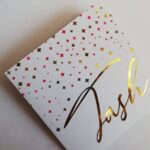 A personalised greeting card with the name Tash on it printed in gold foil.